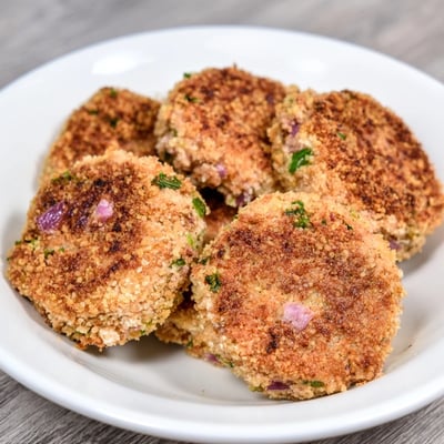 Pan-fried tuna cakes with crunchy exterior and tender flaky inside garnished with chopped parsley
