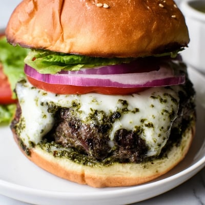 Creamy garlic mayo dripping over a sizzling pesto infused beef burger