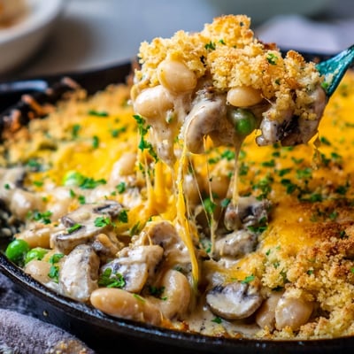 Tender white beans and earthy mushrooms in a rich, bubbling cheddar herb topping